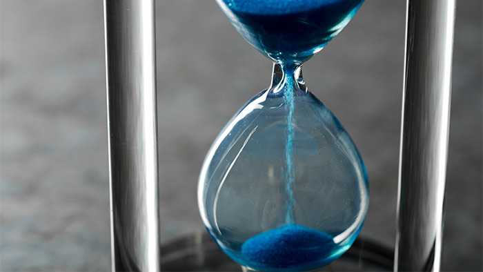 Hourglass with a small amount of sand running into bottom