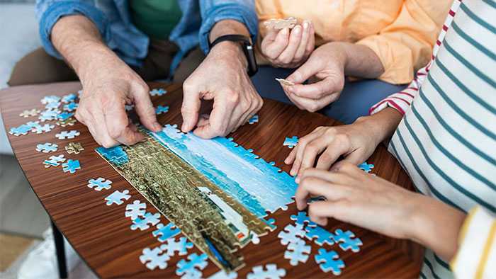 A puzzle coming together in front of three friends