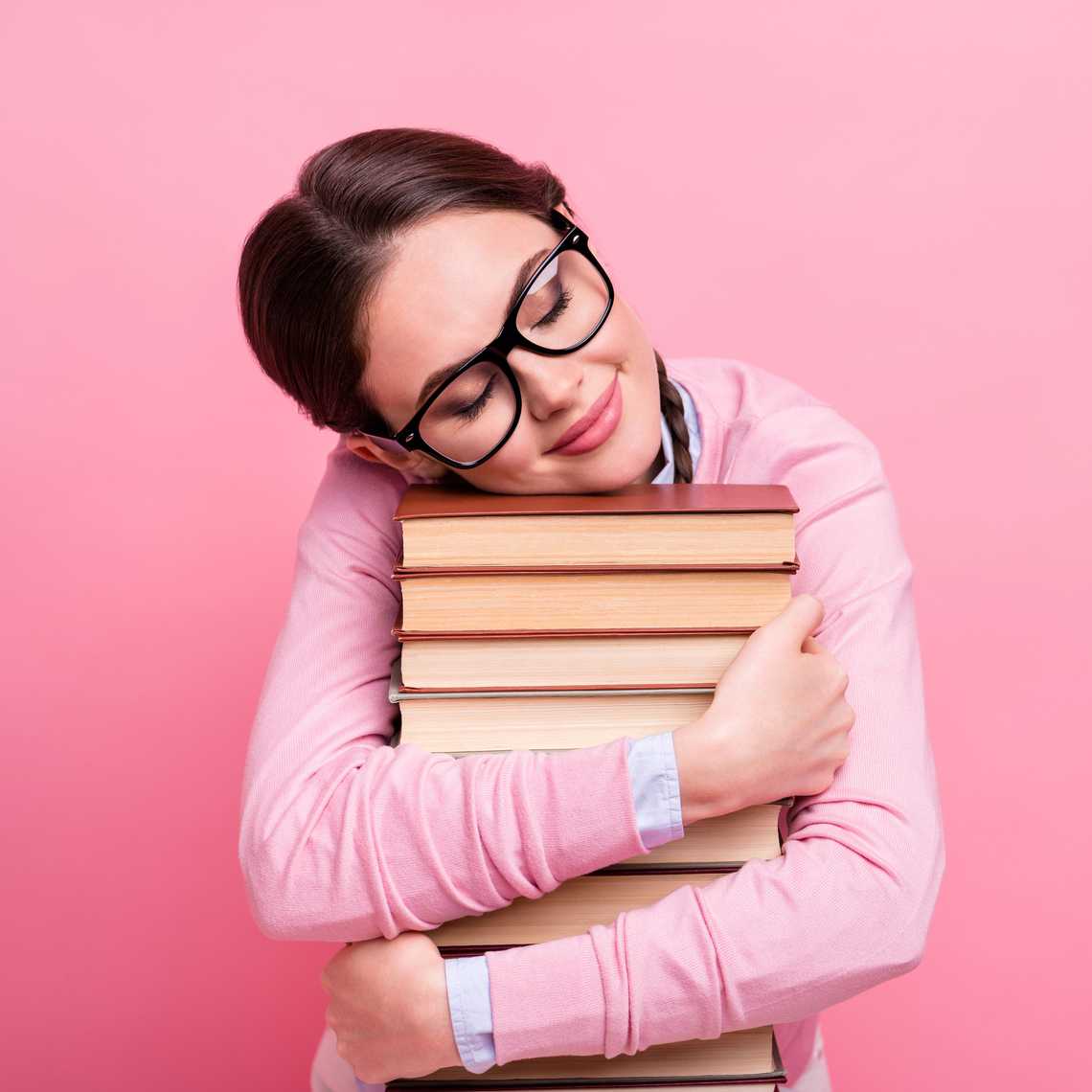 Girl hugs tack of books