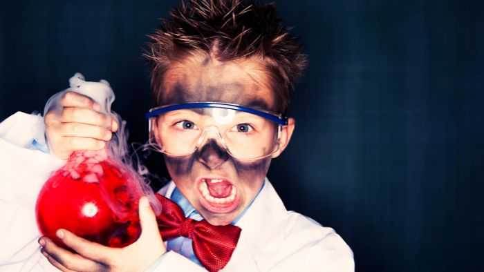mad scientist kid holding beaker of liquid with smoke blackened face