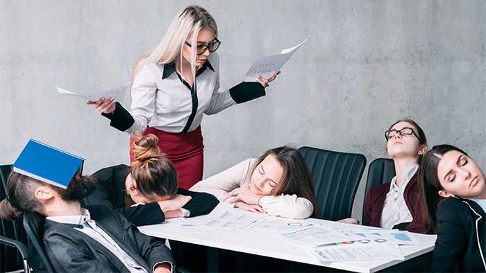 Meeting attendees sleep through a wasteful meeting while the facilitator drones on