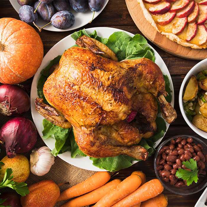 Top down view of thanksgiving dinner with cooked turkey in center