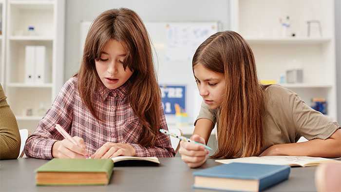 Young girl clearly copying off of the girl setting next to her