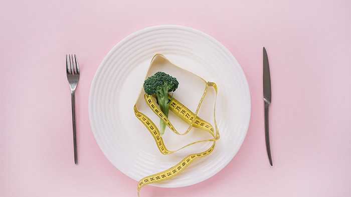 Broccoli and measurement tape on a dish