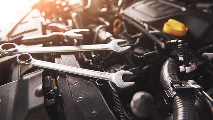 Exposed engine of car with tools laying on top