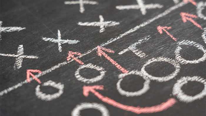 Football team strategy written on a chalk board