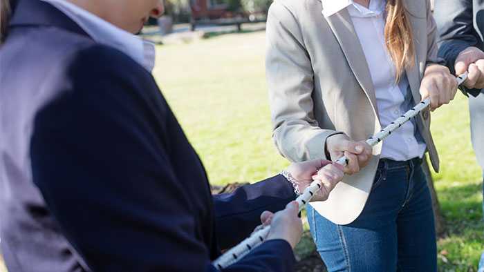 Business people playing tug of war