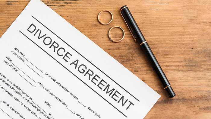 Legal document on a desk next to wedding rings and pen