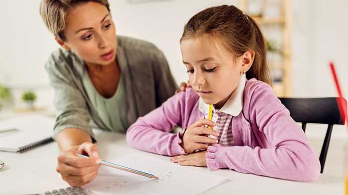 Frustrated mom helping sad daughter with math homework