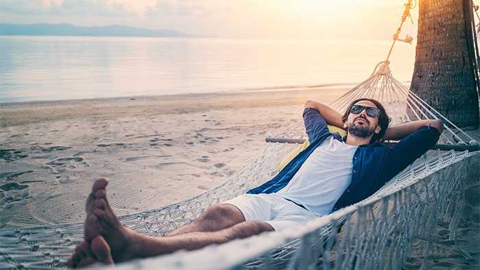 Dude relaxing on a beach in a hammock