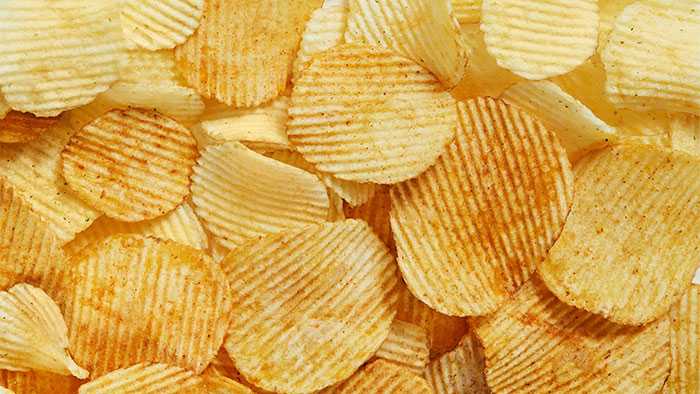Full screen close up of ruffled potato chips