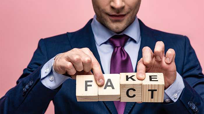 Shady team member holds letter blocks that spell either fake or fact