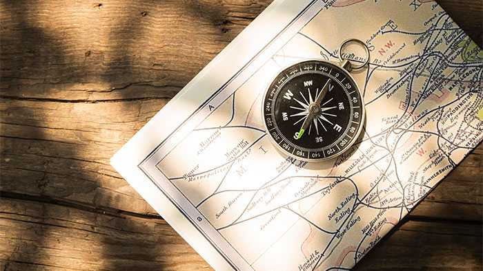 Map and compass with wooden background