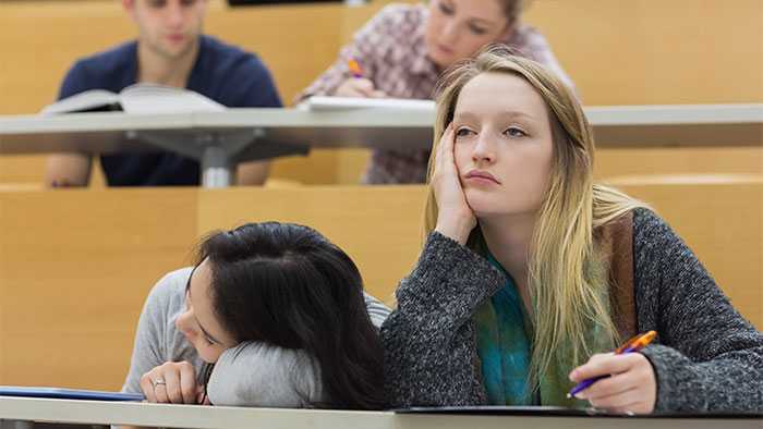 Two bored mentees in a classroom setting. One fighting sleep and one succumbed.